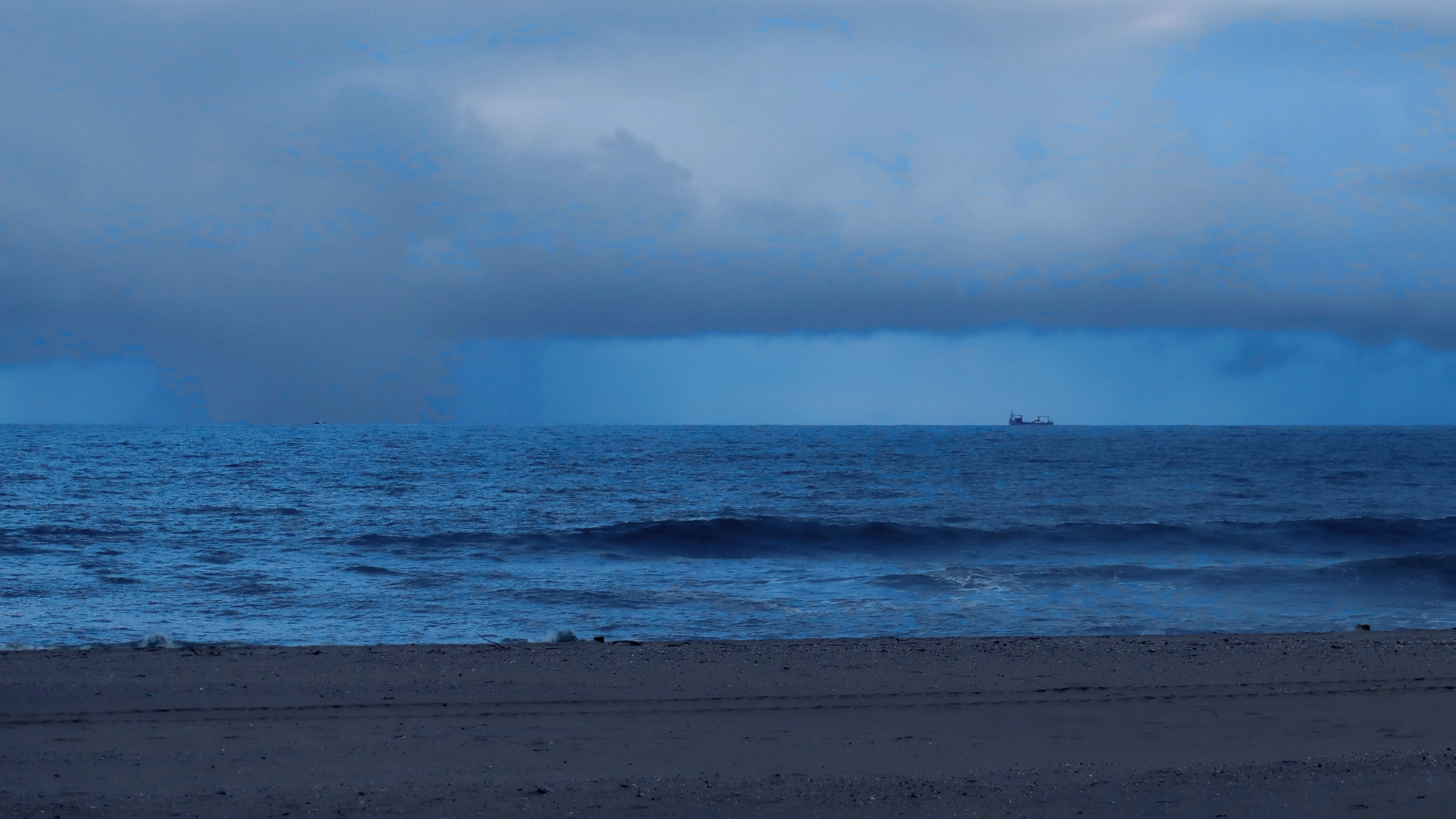 Barco y nube de lluvia en el mar